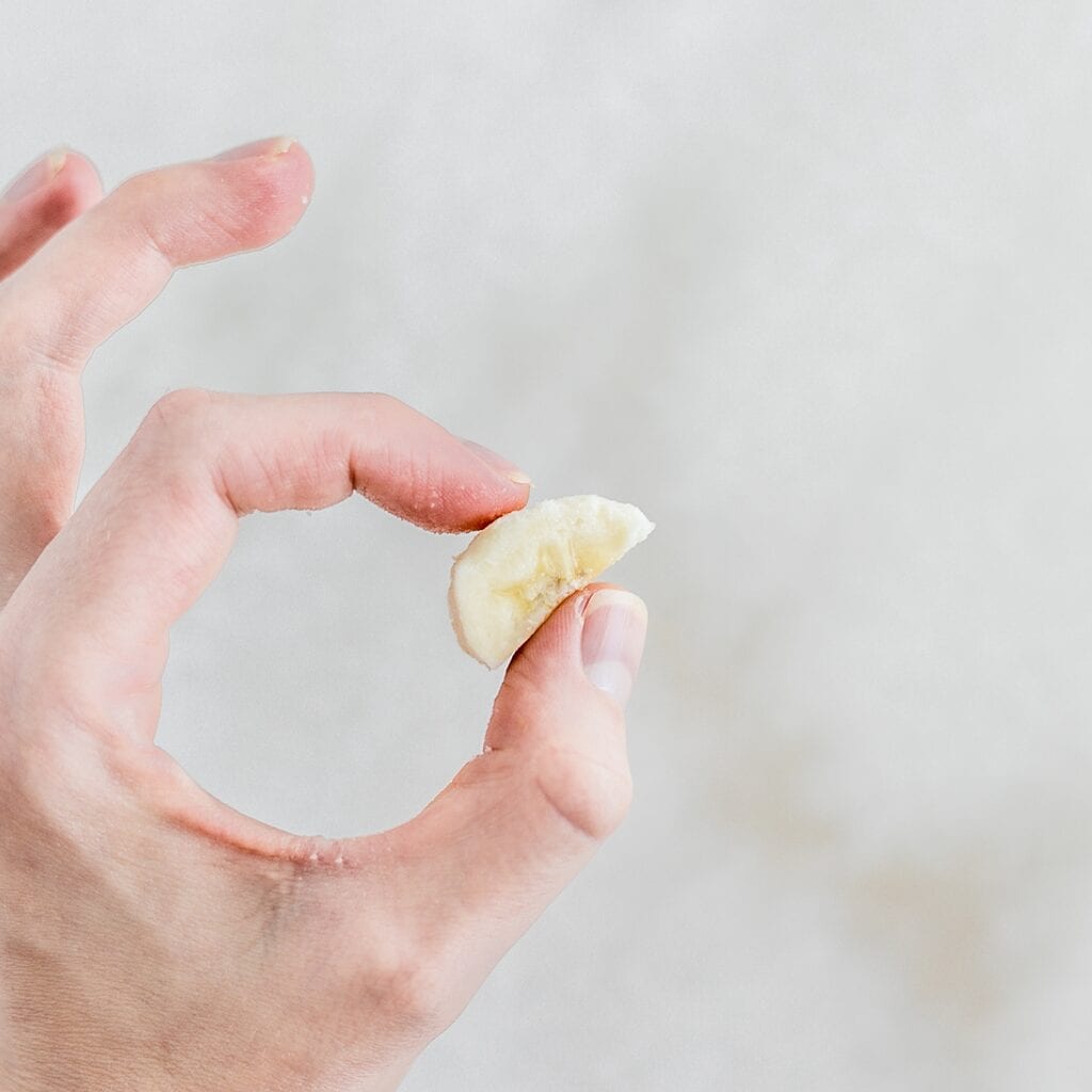 slice of banana held between thumb and forefinger for smash test.