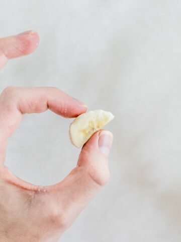 slice of banana held between thumb and forefinger for smash test.