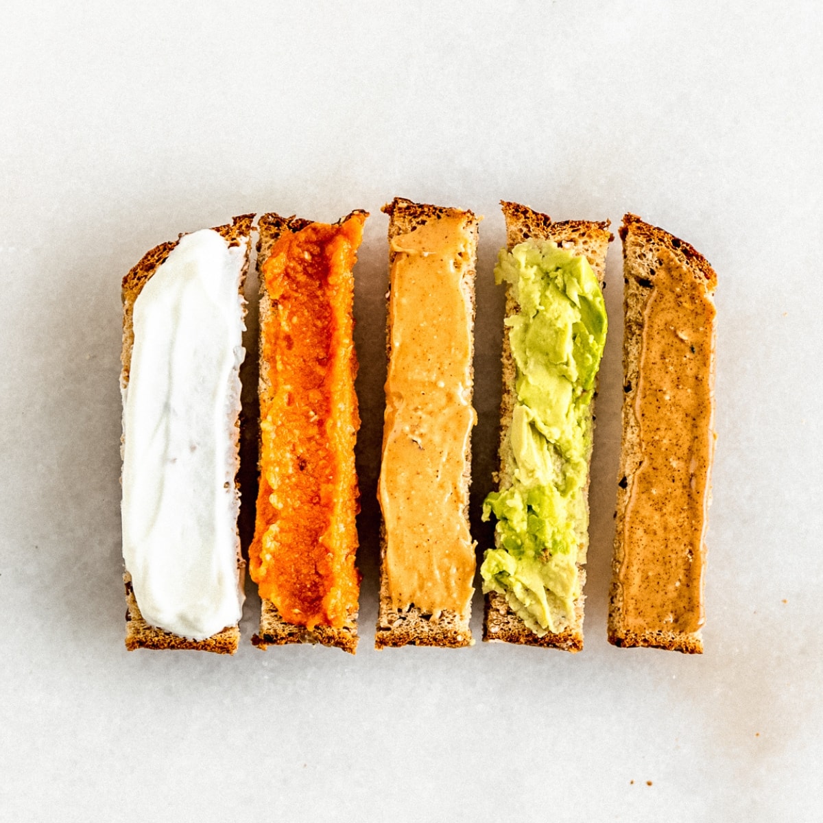 toast cut into fingers for baby led weaning with different spreads on each piece.