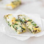 two strips of baby mushroom spinach egg bake on parchment paper.