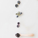 four methods of serving blueberries for baby led weaning lined up on a white marble background.