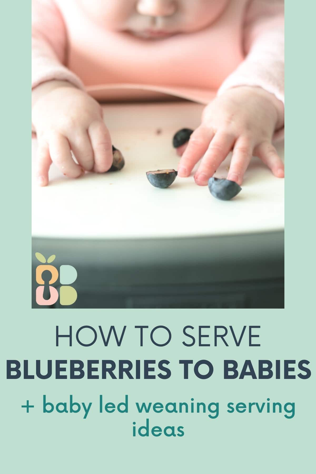 baby hands reaching for halved blueberries on a tray with text overlay.