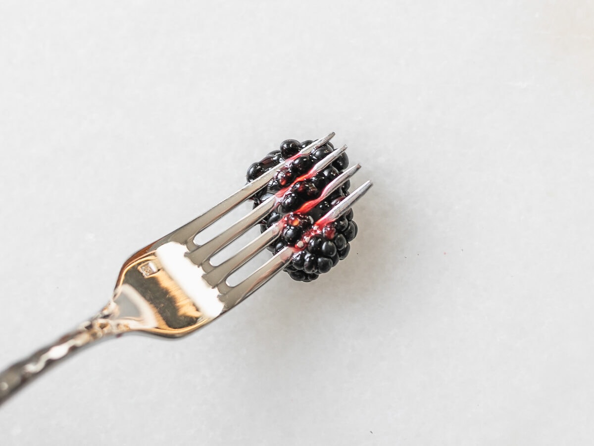 fork mashing a blackberry.