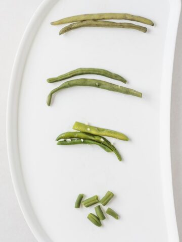 overhead view of green beans prepared various ways on a baby tray.