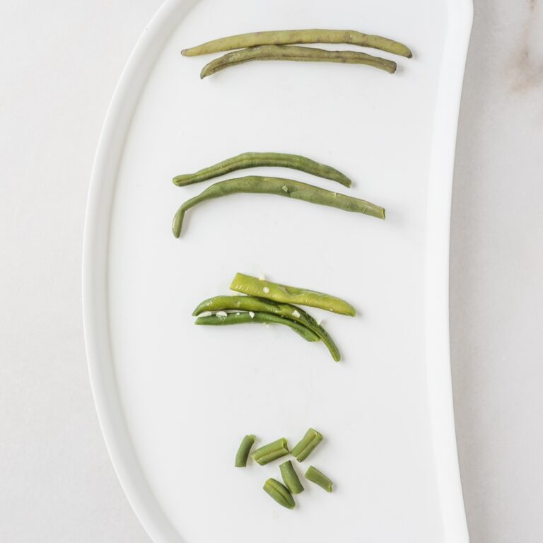 overhead view of green beans prepared various ways on a baby tray.