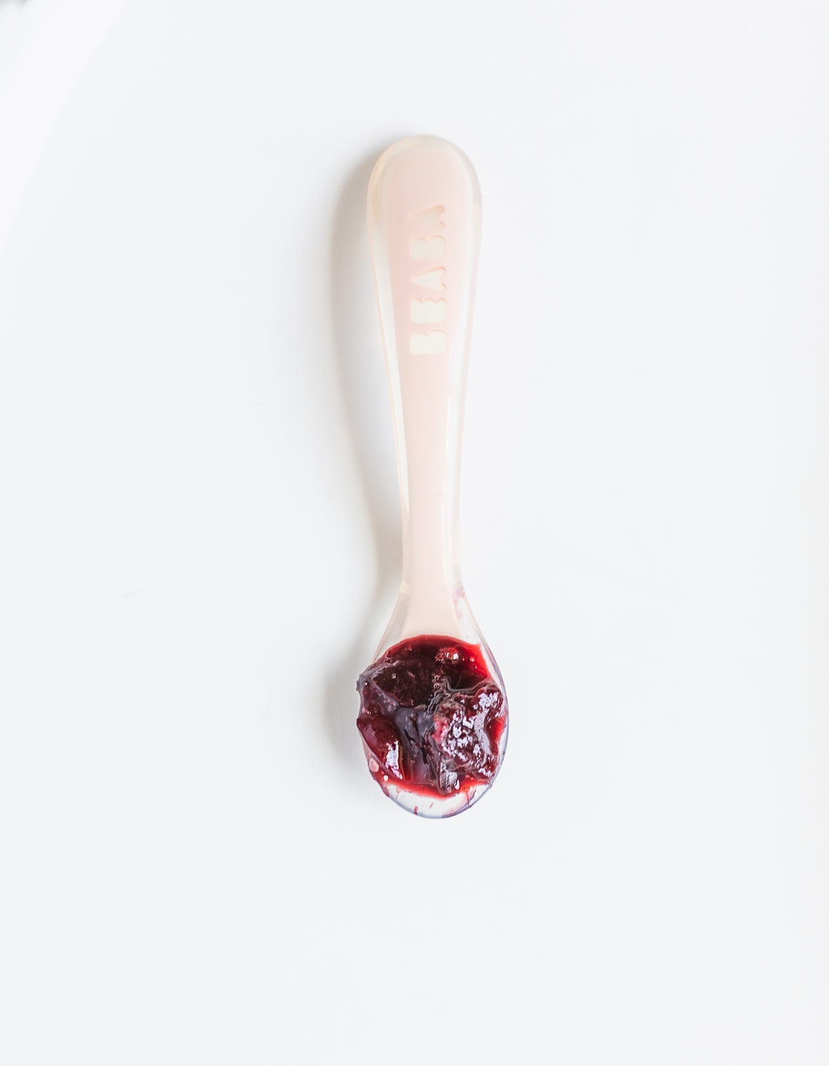 cherry compote on a pink baby spoon.