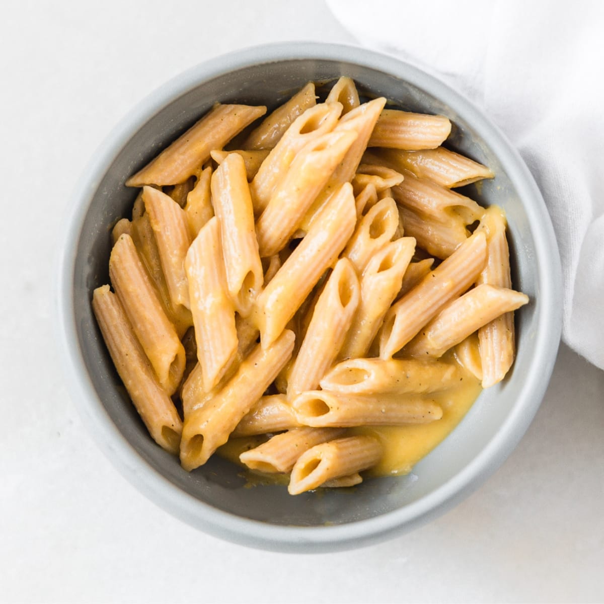 baby bowl of penne pasta with butternut squash pasta sauce.