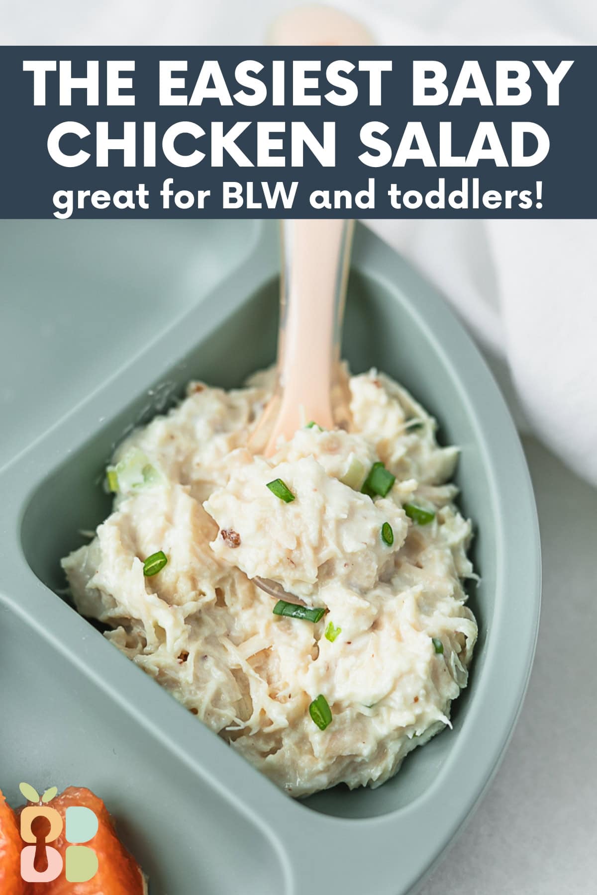 baby chicken salad with a spoon in it on a baby plate.