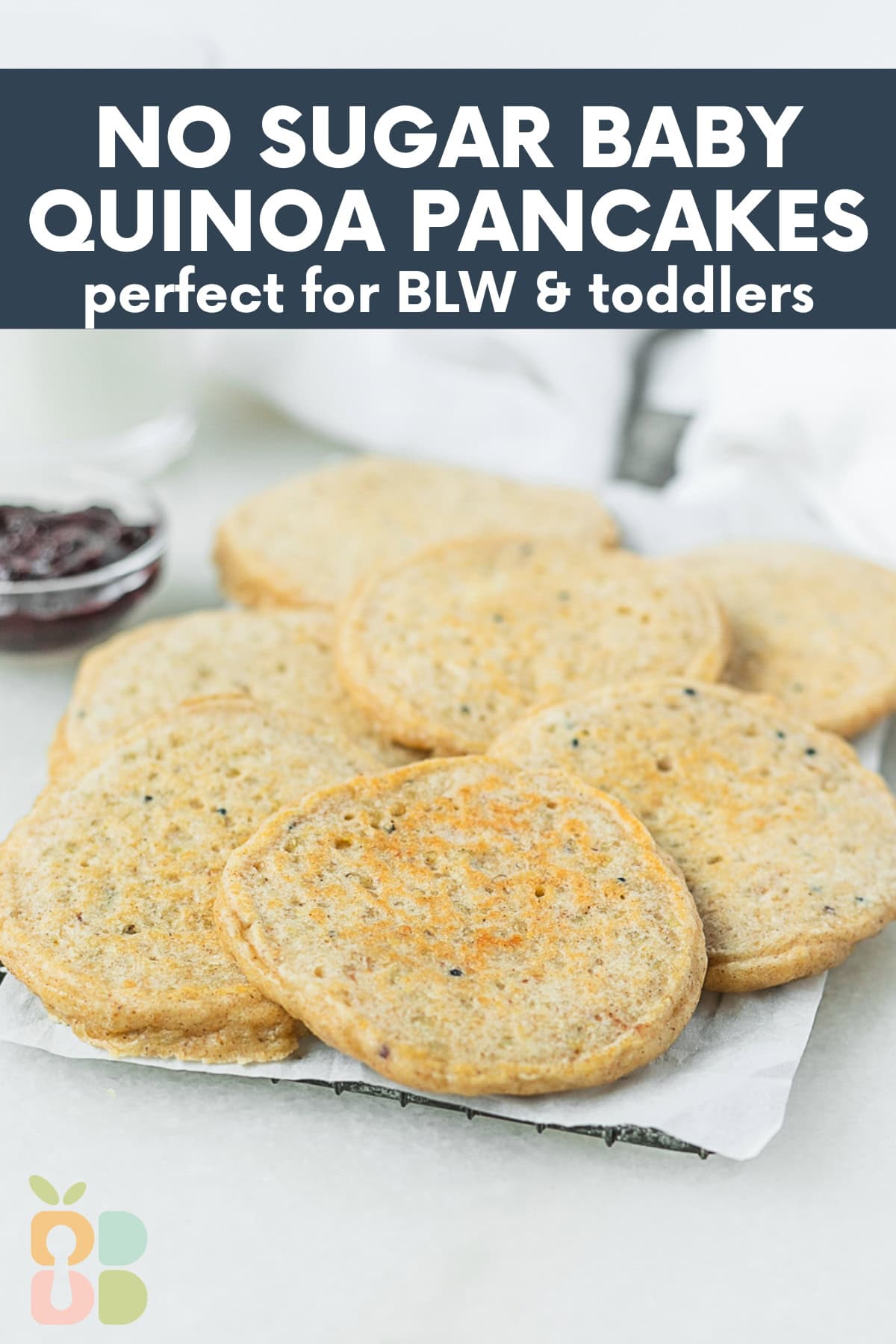 baby quinoa pancakes spread on a rectangular tray with text overlay.