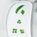 baby tray with snap peas prepared and cut for different stages of baby led weaning.