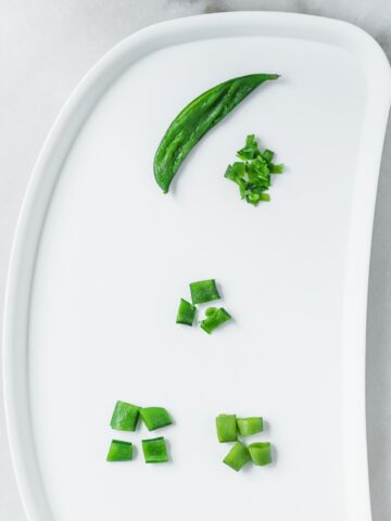 baby tray with snap peas prepared and cut for different stages of baby led weaning.