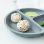 salmon and rice sushi balls on a grey baby plate.