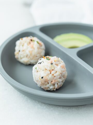 salmon and rice sushi balls on a grey baby plate.