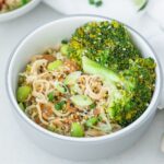 bowl of peanut noodles with broccoli and edamame in a baby bowl.