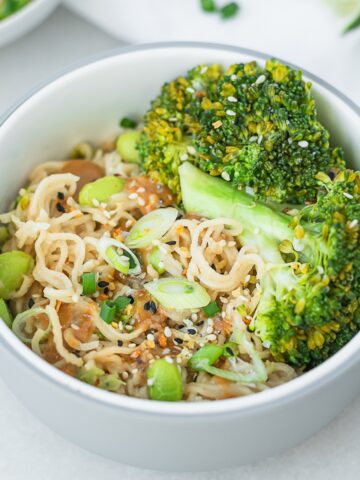 bowl of peanut noodles with broccoli and edamame in a baby bowl.