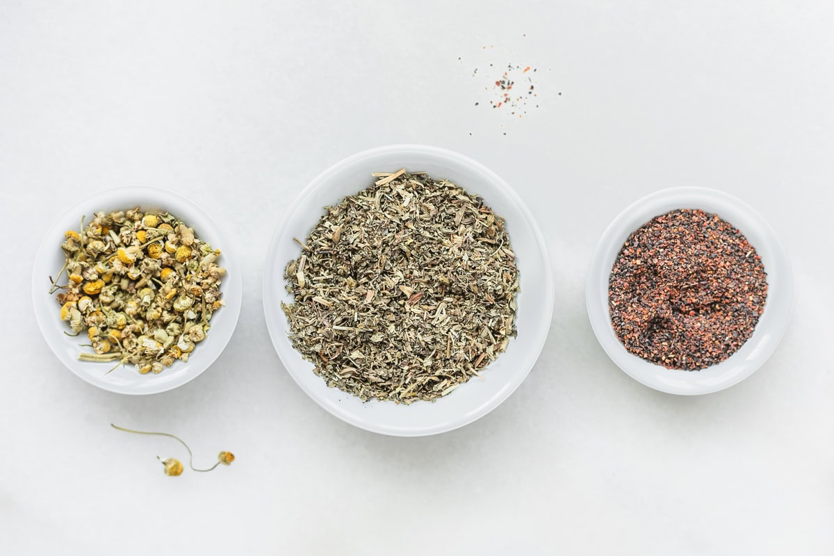 small bowls of dried chamomile, lemon balm and rosehip.