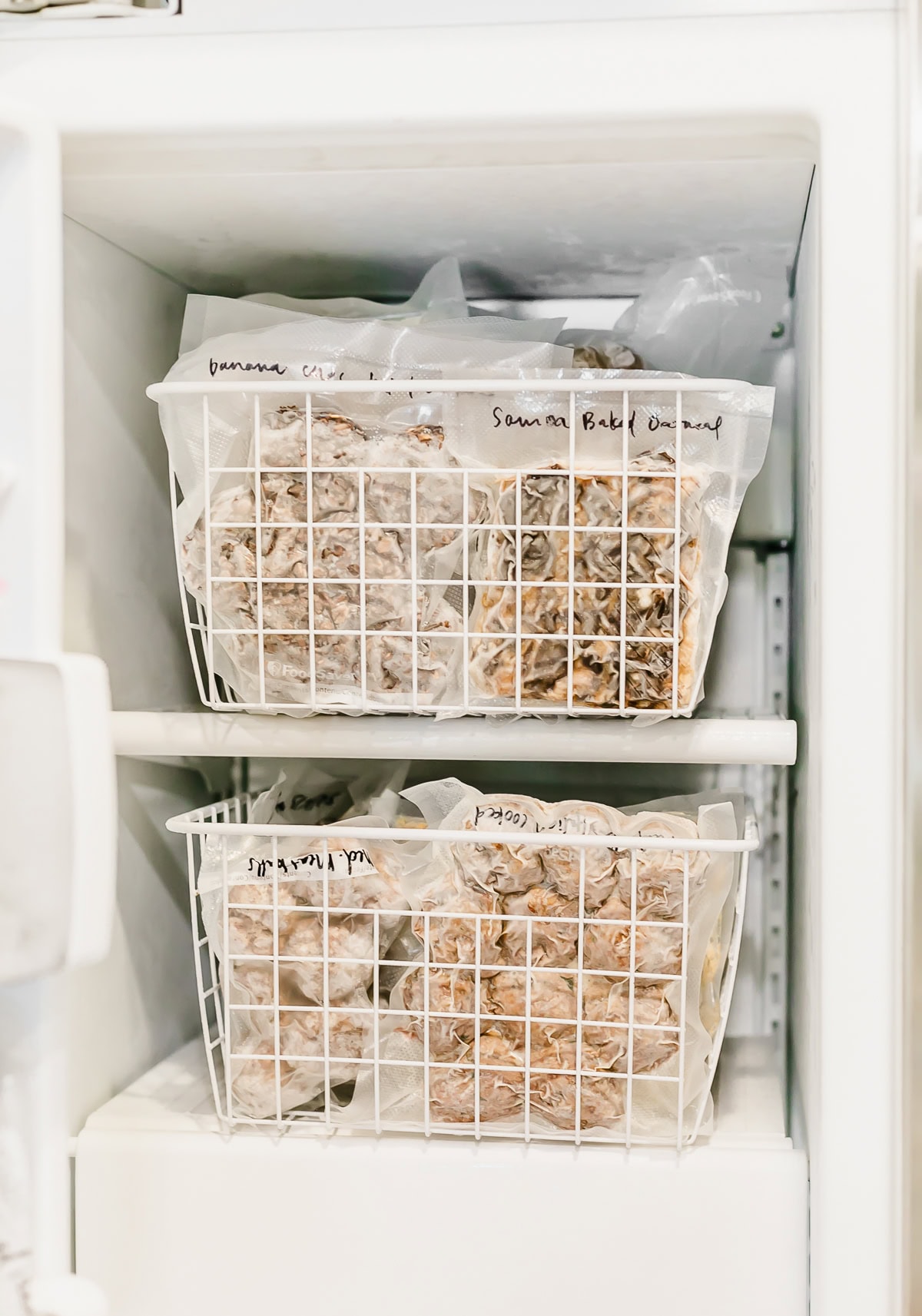 two wire freezer baskets in the freezer with meals and snacks for postpartum.