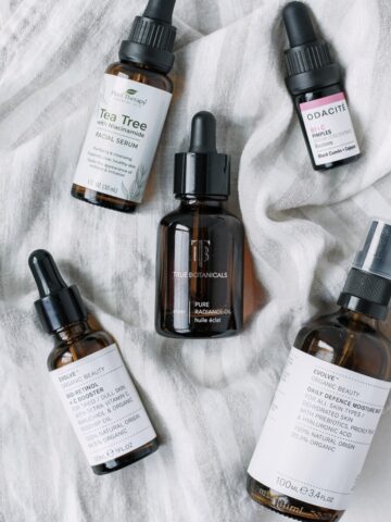 skincare products in amber bottles on a striped linen towel.