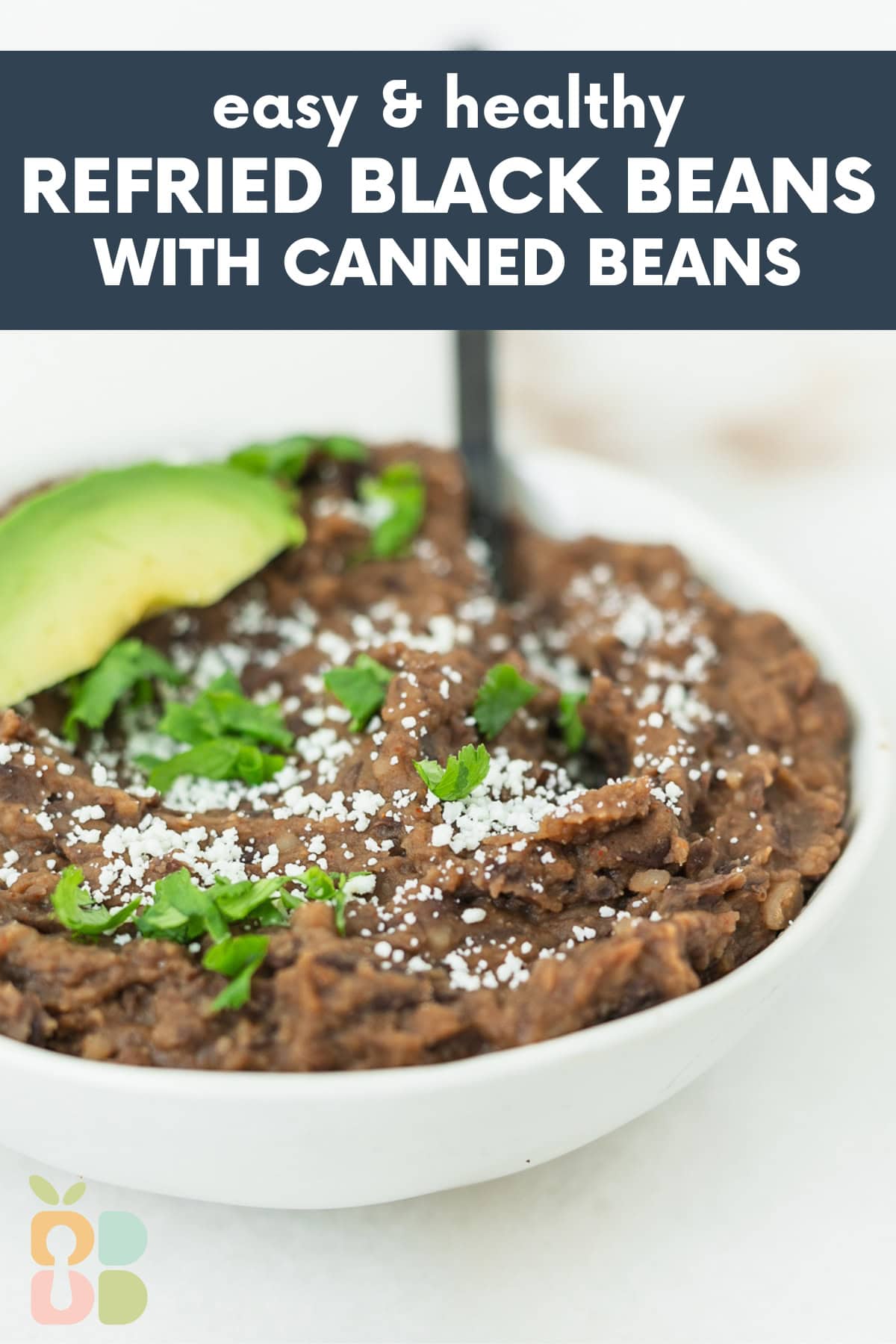 easy refried black beans in a white bowl topped with cotija cheese, cilantro and an avocado slice with text overlay.