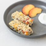 peaches and cream baked oatmeal cut into finger strips for baby led weaning on a grey baby plate.