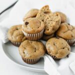 mini banana peanut butter protein muffins piled on a small plate.