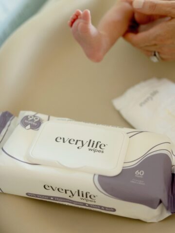 everylife wipes and diaper on a changing pad with baby feet behind them.