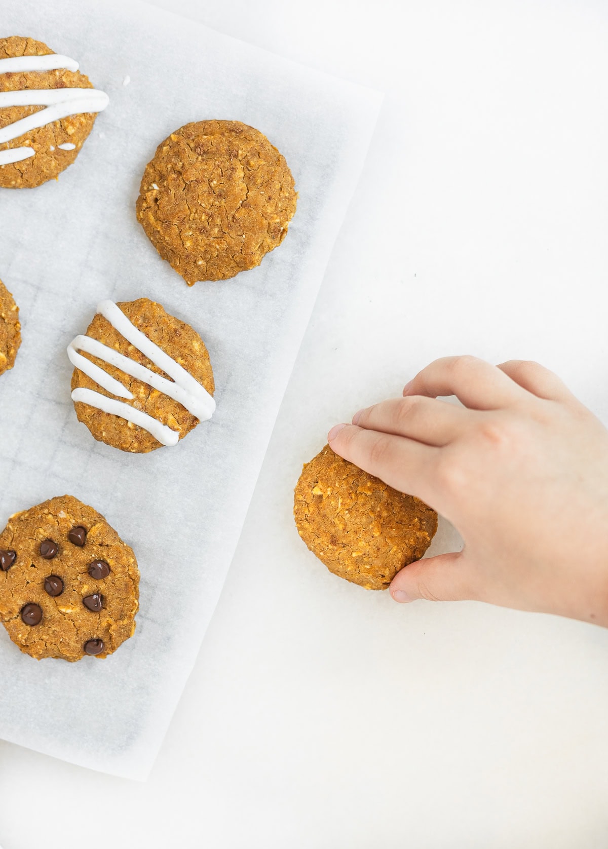toddler hand grabbing a pumpkin chickpea cookie.