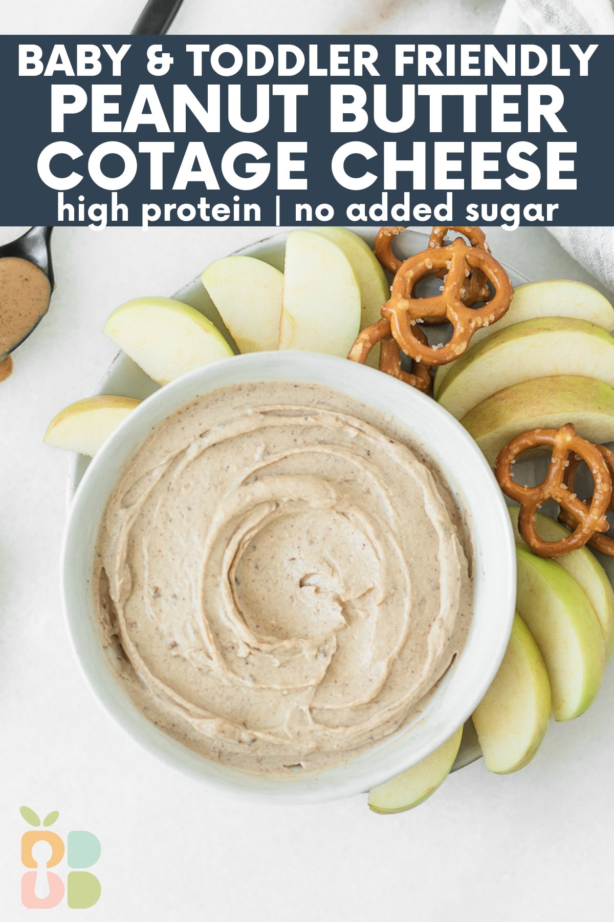 overhead view of peanut butter cottage cheese fruit dip in a bowl surrounded by apple slices and pretzels with text overlay.