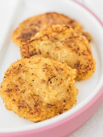 three spaghetti squash fritters on a baby plate.