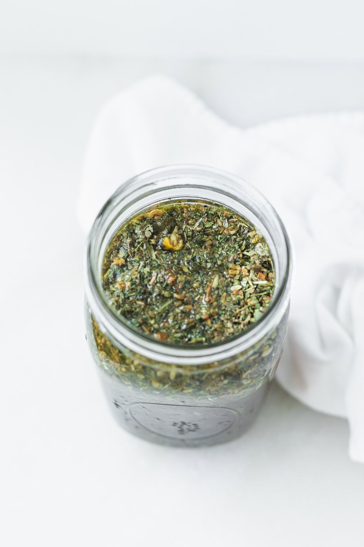 herbal lactation tea blend being brewed in a mason jar.