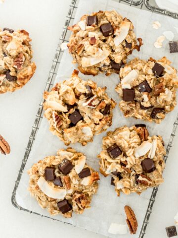 5 dairy free coconut pecan chocolate chip lactation cookies on a wire rack.