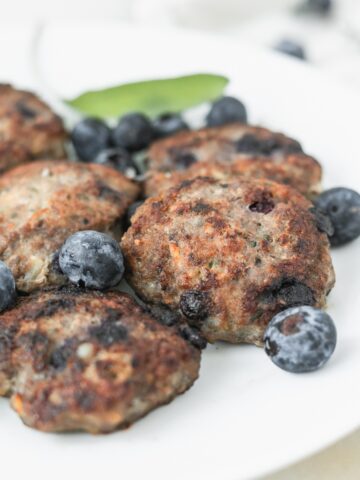 blueberry turkey sausage patties on a plate with blueberries.