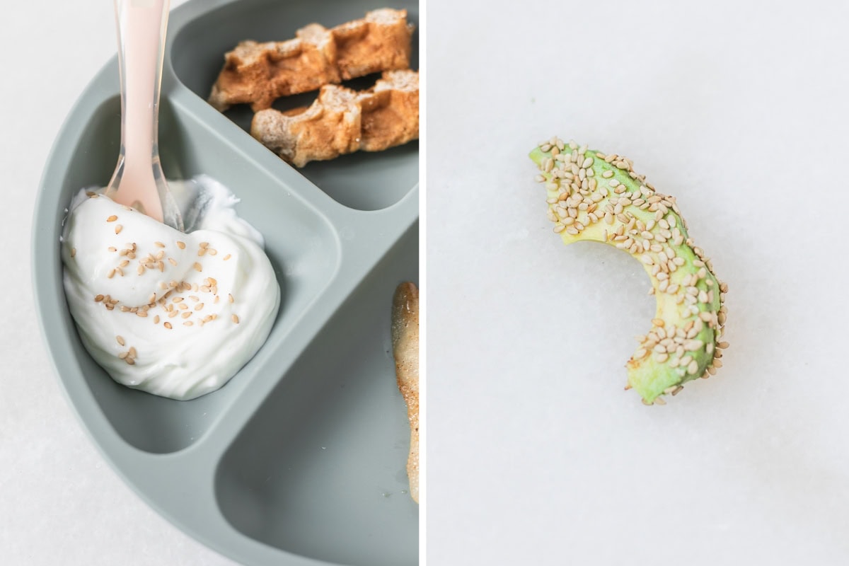 sesame seeds sprinkled on yogurt in a baby plate and avocado slice rolled in sesame seeds.