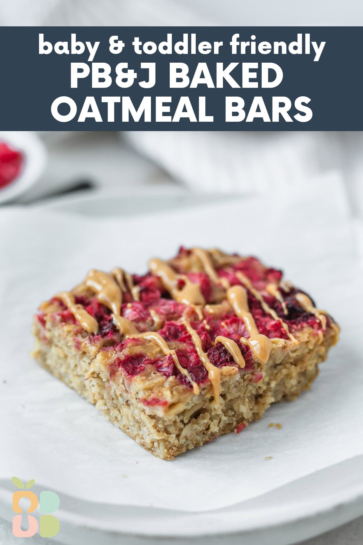 peanut butter and jelly oatmeal bar drizzled with peanut butter on a parchment lined plate with text overlay.